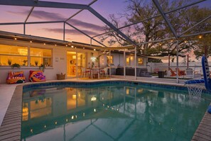 A pool area with a covered patio, outdoor seating, and a view of the house. - Poolside Retreat Sleeps 8 Putt Putt Hot Tub (Bradenton)