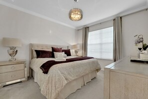 A bedroom with a bed, bedside tables, a lamp, a mirror, and a window with curtains. - Family Escape - Pool Games Dog-friendly (Davenport)