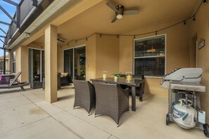 An outdoor patio with wicker furniture, a ceiling fan, and a barbecue grill. - Family Escape - Pool Games Dog-friendly (Davenport)