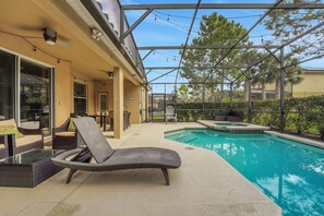 A poolside area with a lounge chair, a hot tub, and a covered patio. - Family Escape - Pool Games Dog-friendly (Davenport)