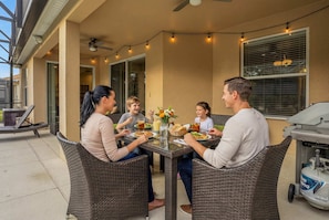 A patio with wicker furniture, a grill, and string lights. - Family Escape - Pool Games Dog-friendly (Davenport)