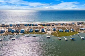 An aerial view of a coastal area with multiple buildings, a marina with boats, and a beach. - Gulf Shores Retreat Heated Pool Lagoon 4BR (Gulf Shores)