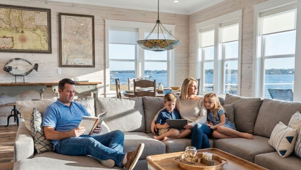 Una familia en una sala de estar bien iluminada, con vista al agua.