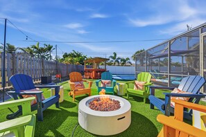 A backyard with a fire pit, outdoor seating, and a pool. - Sleeps 14 Sport Court Tiki Bar Heated Pool (Bradenton)