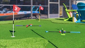 Un campo da mini golf con buche numerate e un edificio sullo sfondo.