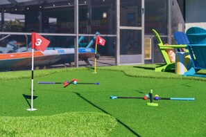Ein Minigolfplatz mit nummerierten Bahnen und einem Gebäude im Hintergrund.