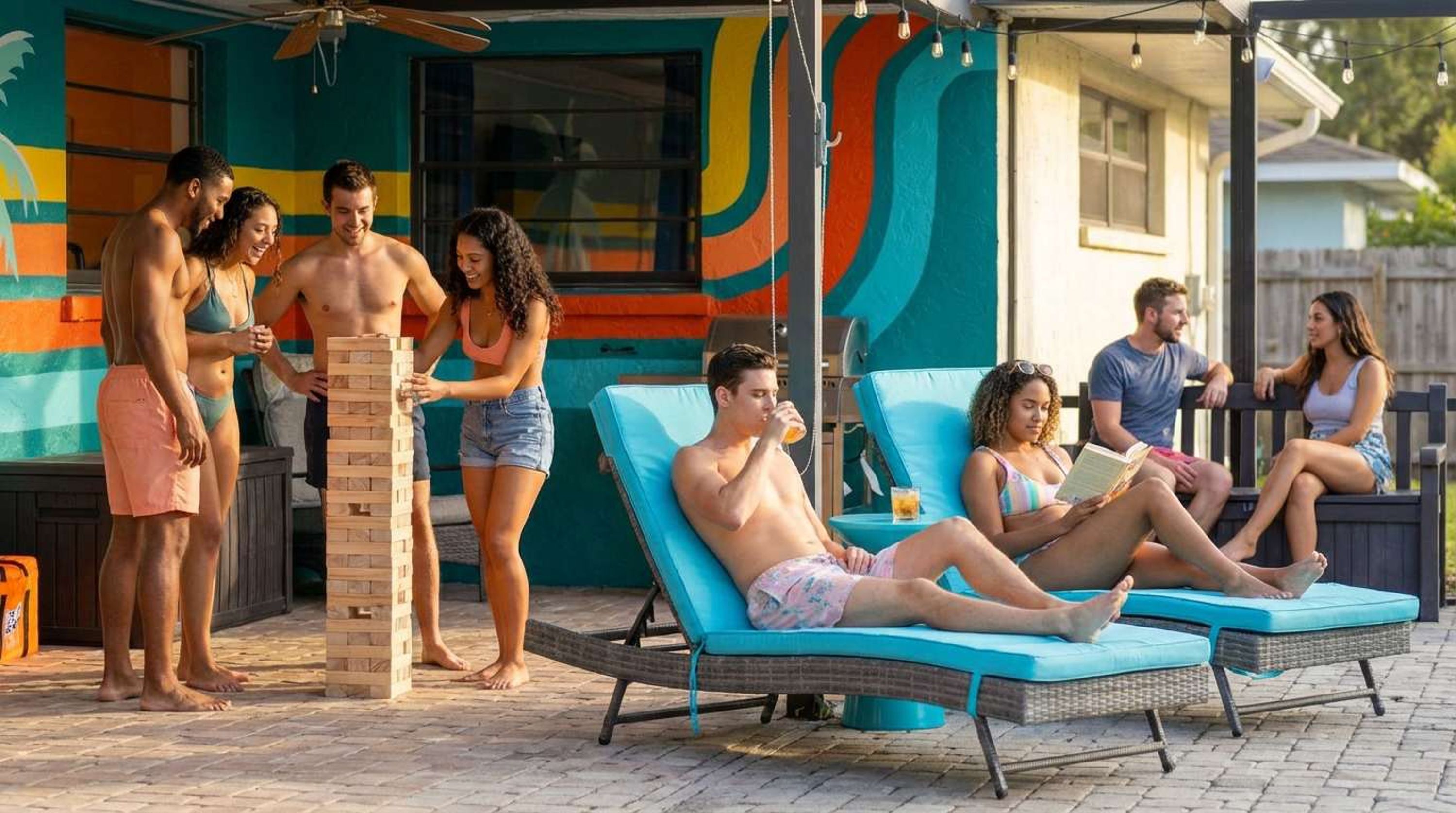 Zona junto a la piscina con sillones de descanso y una estructura de juegos de madera.