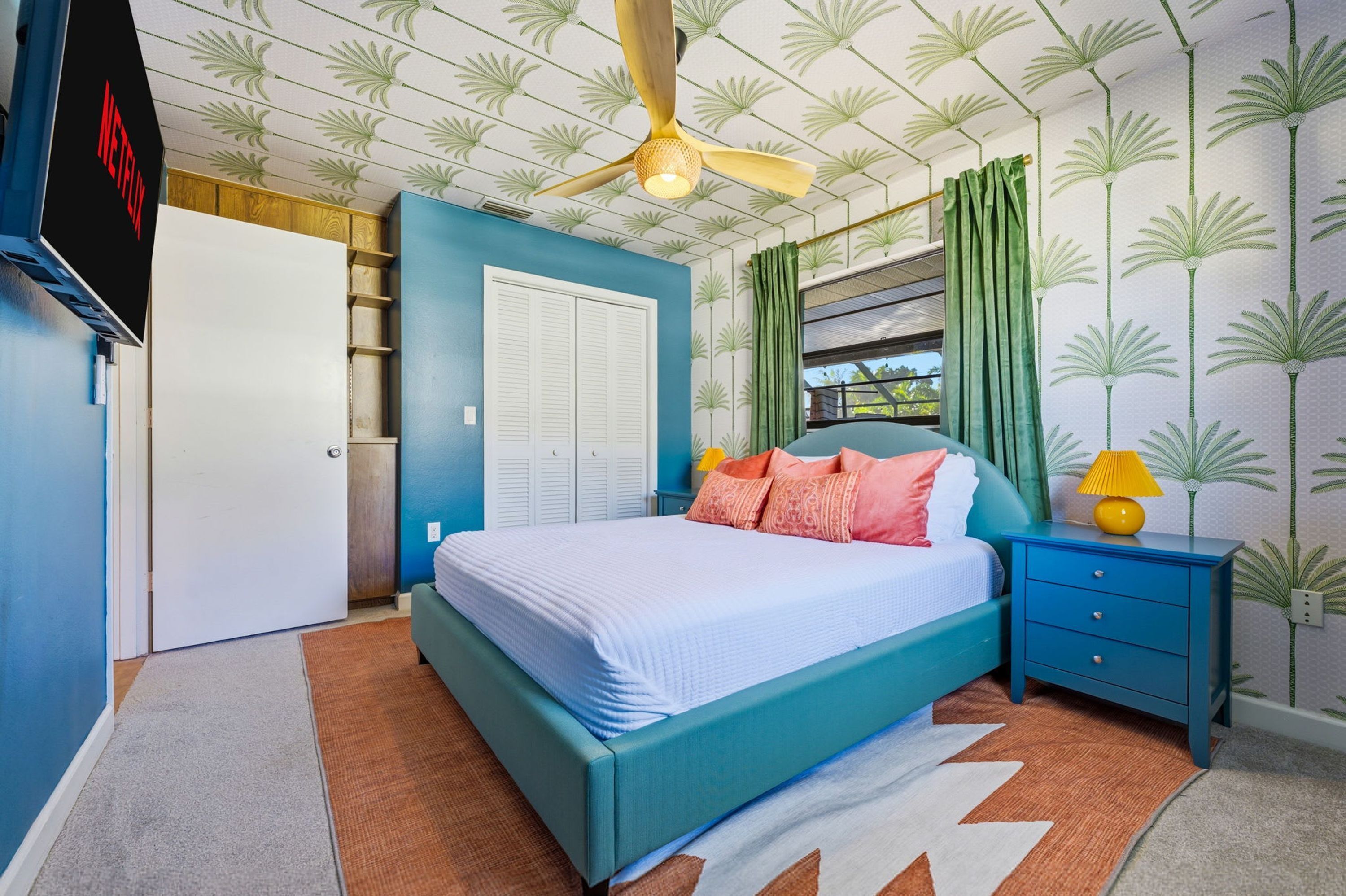 A bedroom with a bed, a nightstand, a wardrobe, and a ceiling fan.
