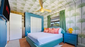 Una camera da letto con un letto, un comodino, un armadio e una ventola a soffitto.