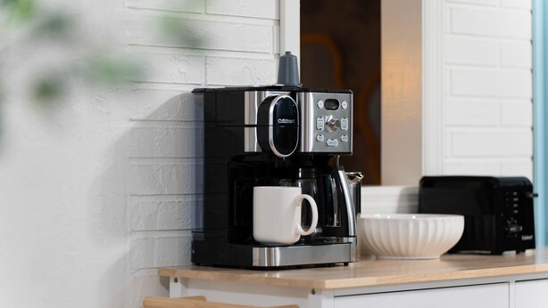 A coffee maker on a countertop with a white mug, a bowl, and a drawer. - Ultimate Family Retreat - Pool - Games - Hot Tub (Seminole)