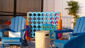 A set of blue Adirondack chairs, a wooden post, and a colorful plastic board game in a backyard setting. - Ultimate Family Retreat - Pool - Games - Hot Tub (Seminole)
