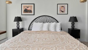 A bedroom with a bed, two nightstands, two lamps, and two framed artworks on the wall. - Private Retreat Buyout Sleeps 16 Spa 4 Units (Warren)