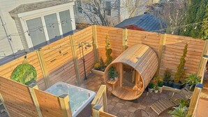 A wooden deck with a hot tub, a sauna, and potted plants. - Private Retreat Buyout Sleeps 16 Spa 4 Units (Warren)