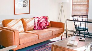 A living room with a sofa, chairs, a coffee table, a floor lamp, and a window with blinds. - Private Retreat Buyout Sleeps 16 Spa 4 Units (Warren)