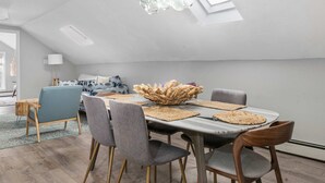 A dining area with a high ceiling, a chandelier, and a table set with placemats and a centerpiece. - Private Retreat Buyout Sleeps 16 Spa 4 Units (Warren)