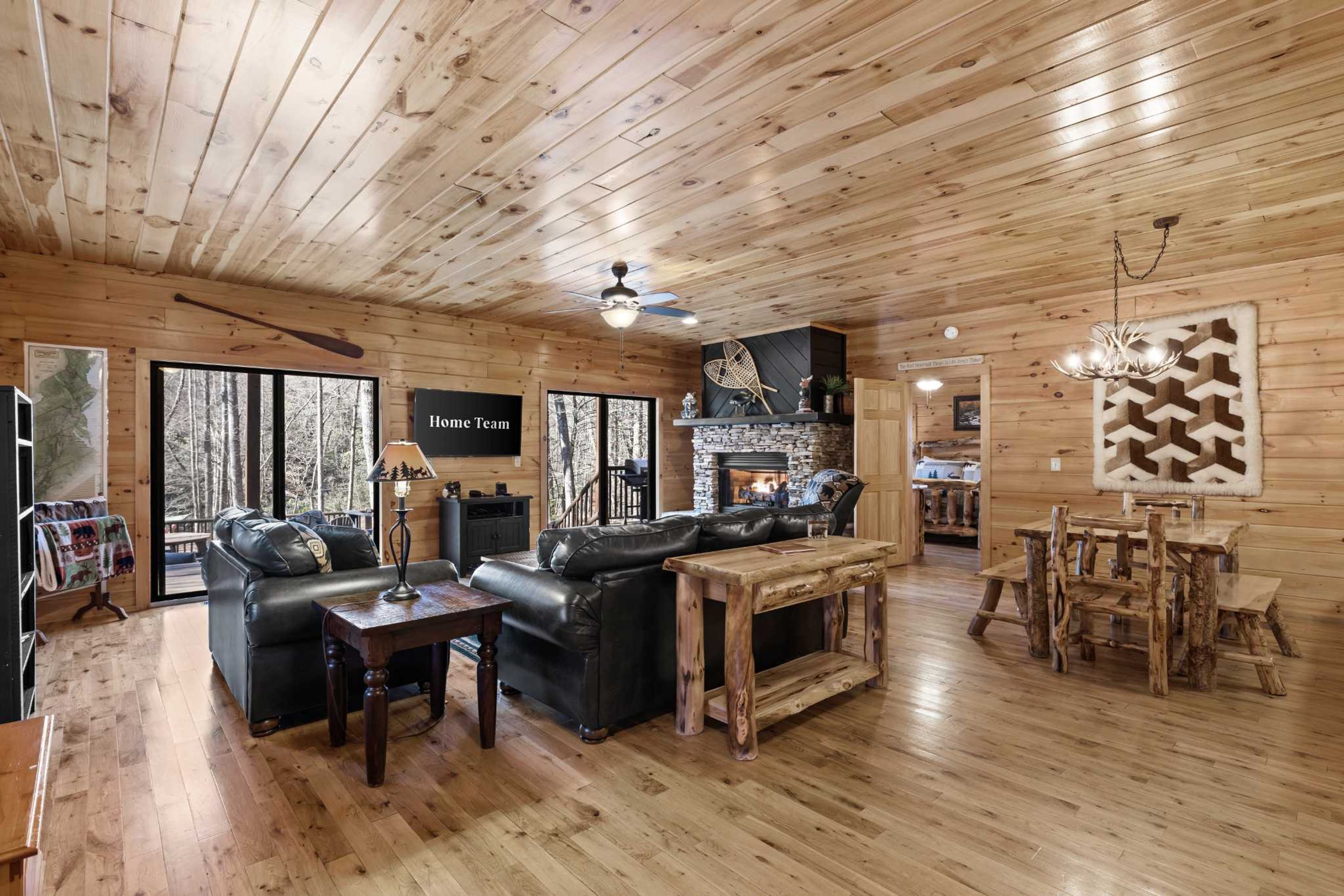 L’intérieur d’une cabane en rondins, avec une cheminée, un canapé en cuir, une table à manger et une pancarte sur laquelle on peut lire : « Équipe locale ».