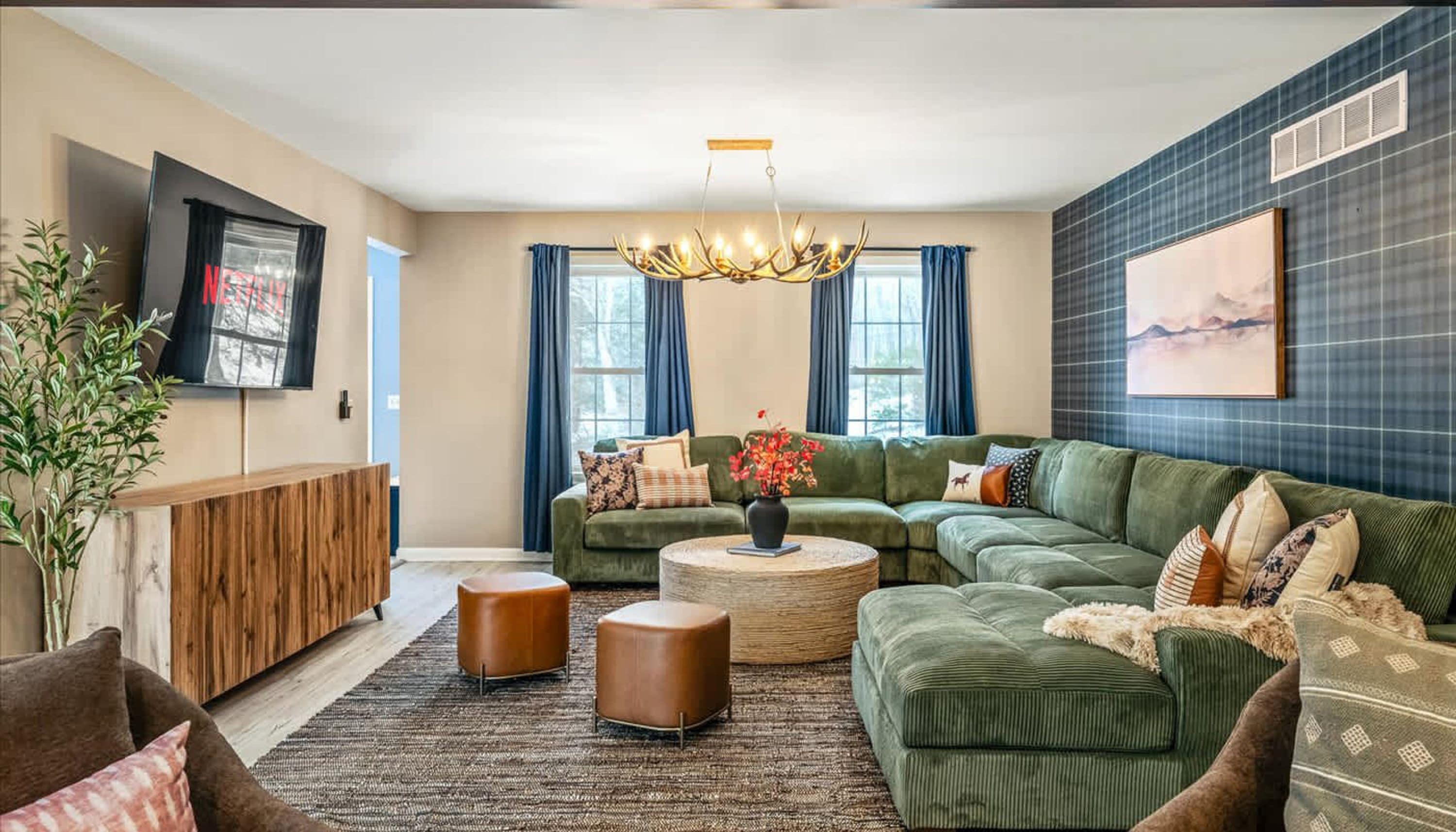 A modern living room with a sectional sofa, a coffee table, and a television mounted on the wall.