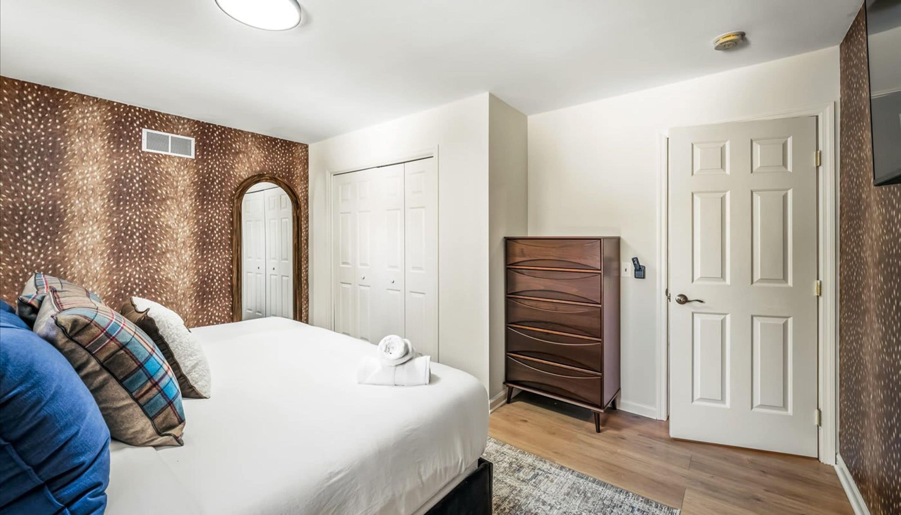 A bedroom with a bed, a wardrobe, and a door.