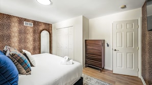 A bedroom with a bed, a wardrobe, and a door. - Epic Poconos Pad Pool Hot Tub Gym Golf Sim (East Stroudsburg)