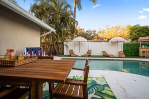 A pool area with lounge chairs and a wooden table. - Heated Pool Game Room Putt Putt Pet Friendly (Largo)