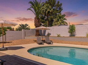 A swimming pool with two lounge chairs and a palm tree in the background. - Sonoran Sunset Retreat Pool Games (Scottsdale)