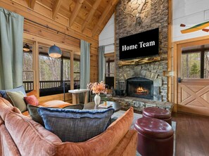 A cozy living room with a stone fireplace, a sofa, and a coffee table. - Best of Blue Ridge Hot Tub Games Pickleball (Cherry Log)