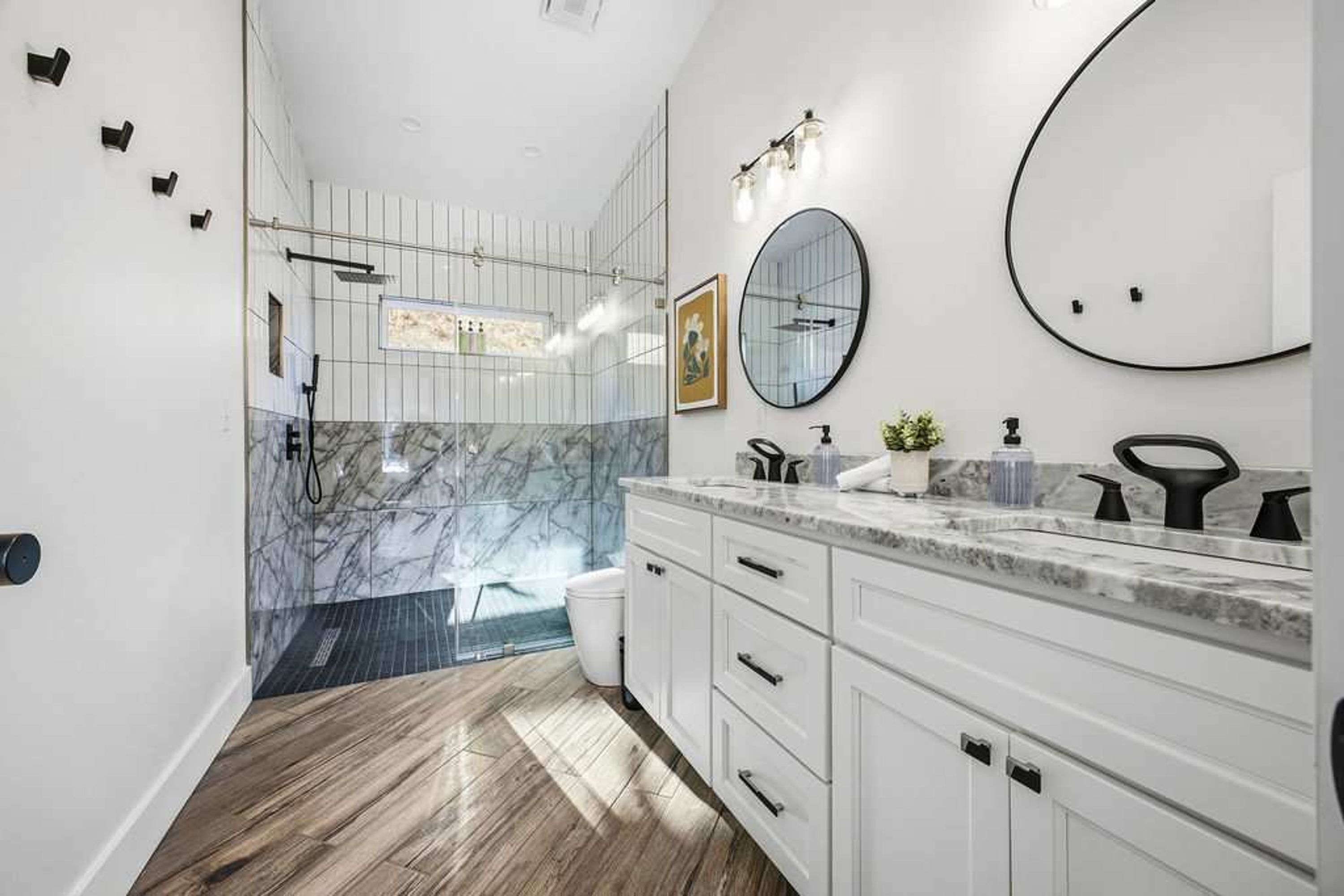 A modern bathroom with a shower, a sink with a mirror, and a toilet.