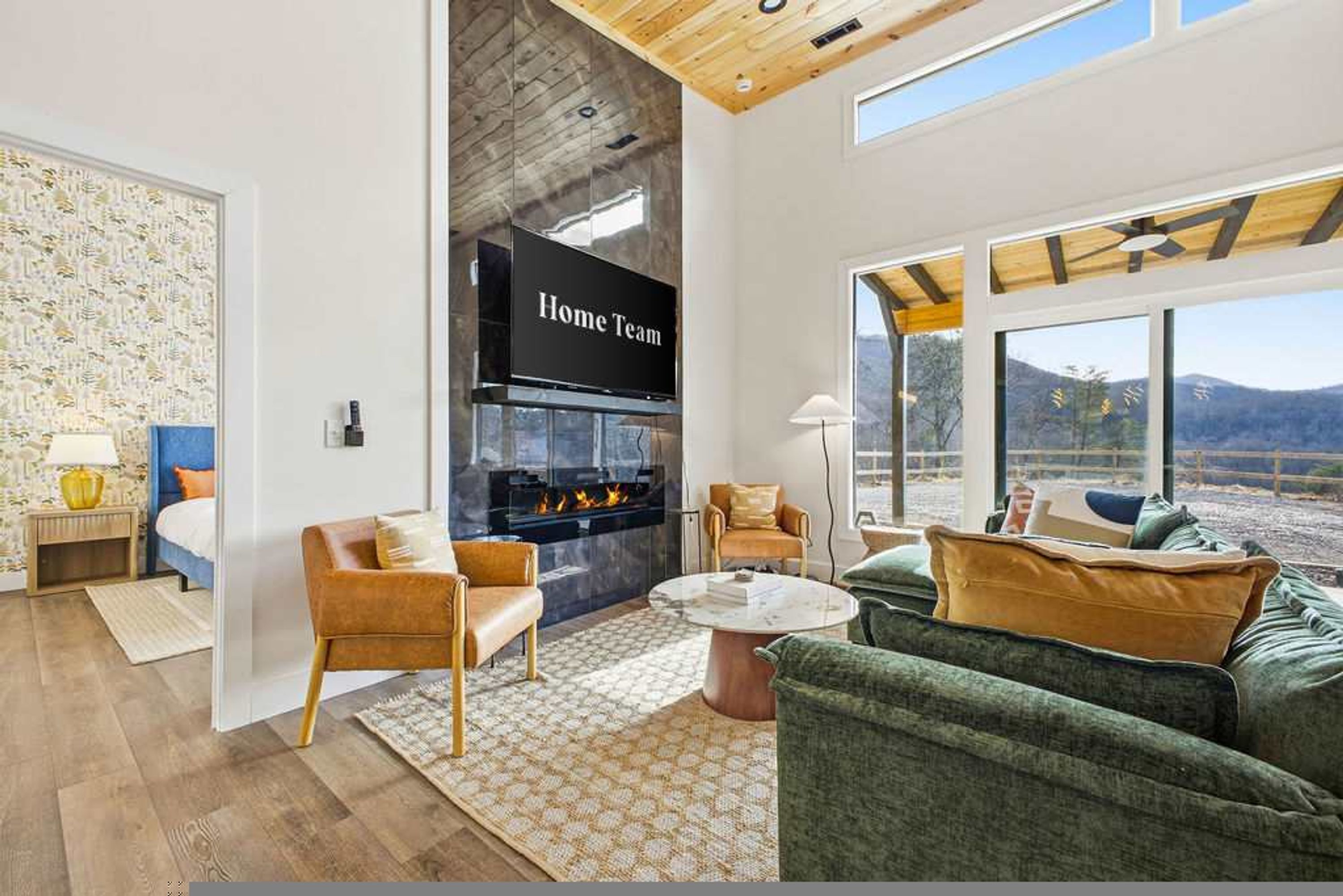 A modern living room with a fireplace, comfortable seating, and a large window offering a view.