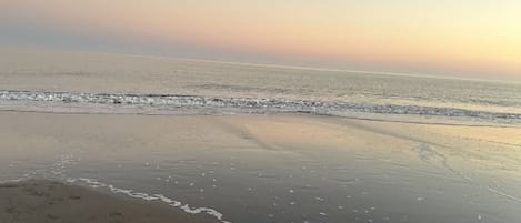 A beach with a calm sea and a clear sky.