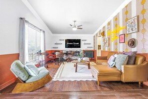A living room with a sofa, armchairs, a coffee table, a TV, and a fireplace. - Private Resort 4 Baths Near Pearl (San Antonio)