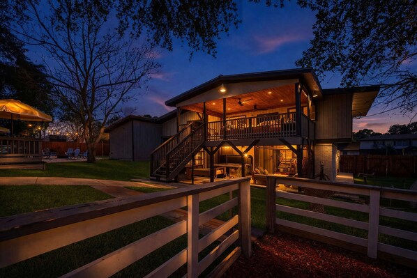 A two-story building with a balcony, a covered patio, and a fenced outdoor area. - Private Resort 4 Baths Near Pearl (San Antonio)