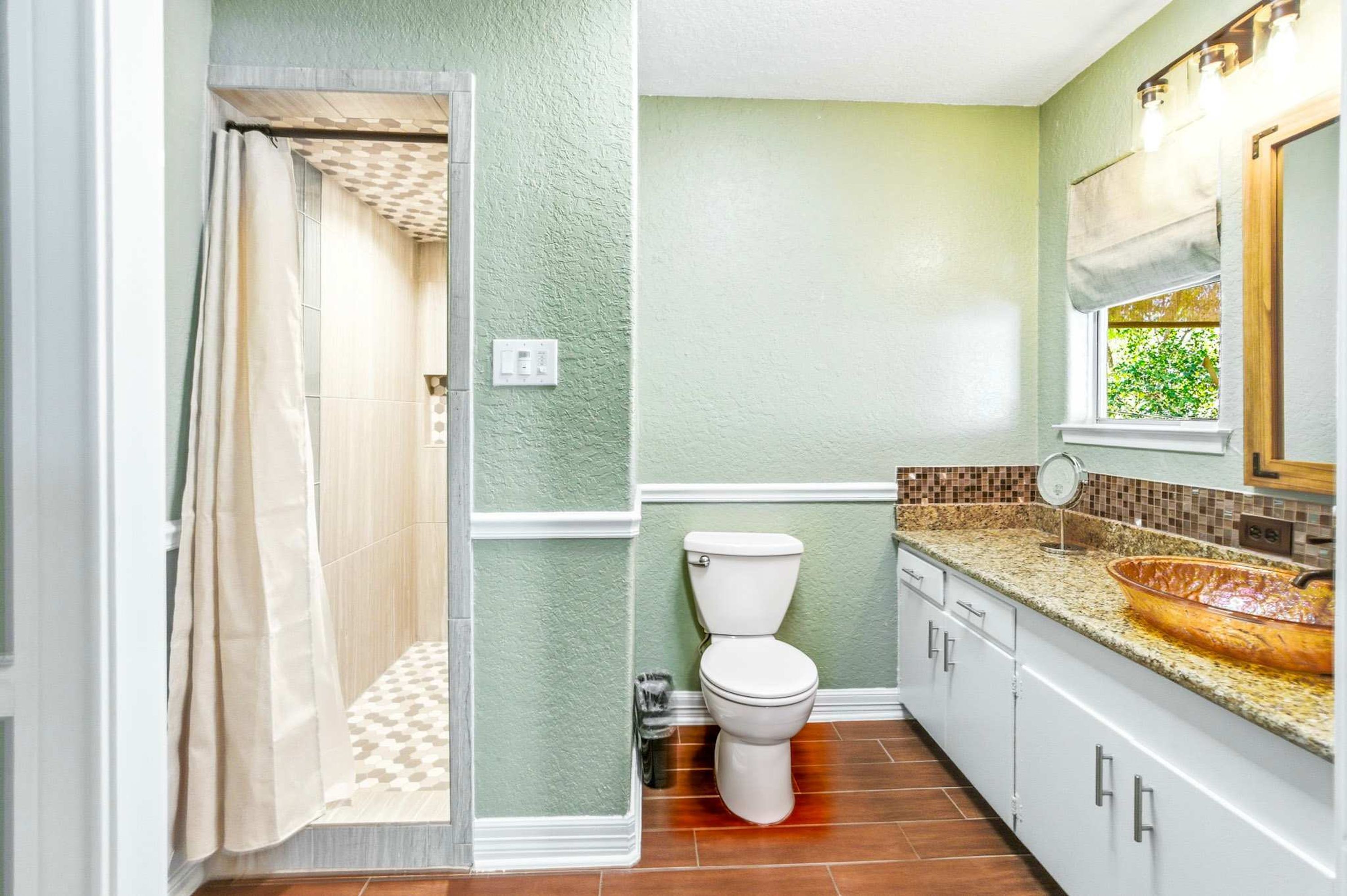 A bathroom with a shower, toilet, and sink.