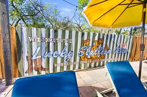 A wooden fence with a welcome sign for Lucky Stadium Villas, featuring a pizza and a fortune wheel. - Private Resort 4 Baths Near Pearl (San Antonio)