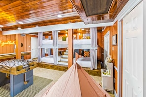 A room with bunk beds, a foosball table, and a neon sign. - Private Resort 4 Baths Near Pearl (San Antonio)