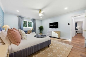 Ein Hotelzimmer mit einem Bett, einem Fernseher, einem Schreibtisch und einer Pflanze.