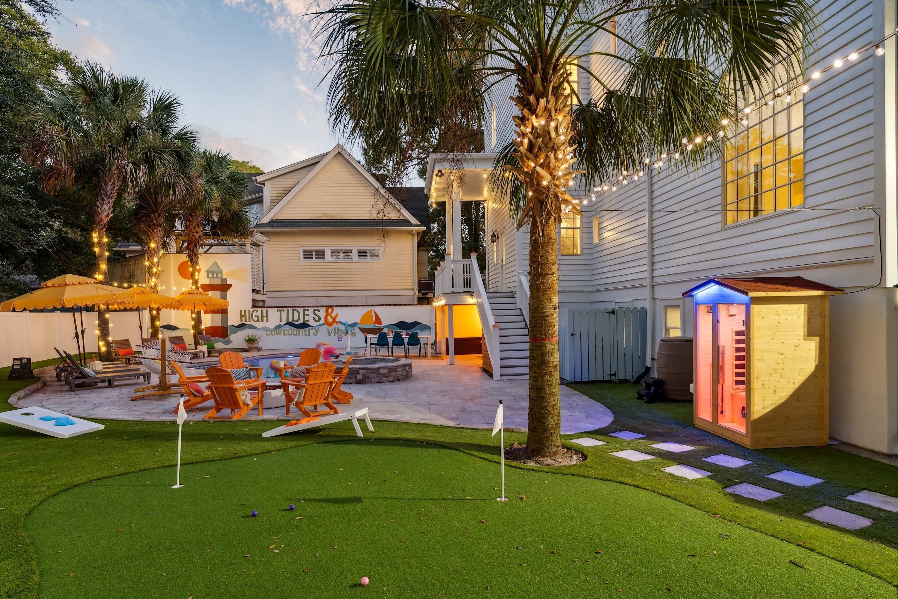 Un jardin avec une piscine, un espace salon extérieur et une aire de jeux.