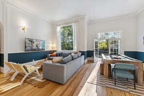 A living room with a grey sofa, a pool table, and a large window. - Golf Sim Pickleball Theater Sauna Games Sleeps 24 (Hilton Head Island)