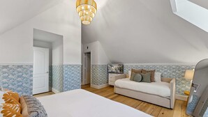 Ein Schlafzimmer mit einem Bett, einer Couch, einem Fernseher und einer Deckenleuchte.