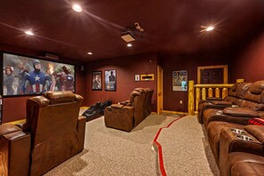 A home theater room with leather recliners, a large screen, and framed movie posters. - Private Mtn Views Movie Theater Hot Tub Pool Table (Sevierville)
