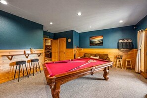 A pool table in a room with wooden walls and a blue accent wall. - Private Mtn Views Movie Theater Hot Tub Pool Table (Sevierville)
