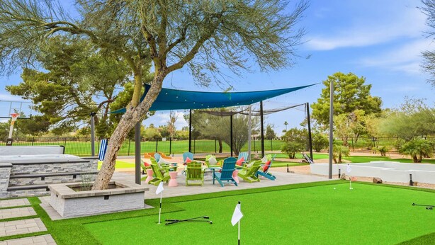 A well-maintained golf course with a putting green, a tee box, and a seating area with chairs. - Scottsdale Retreat Pool Pickleball Spa (Scottsdale)