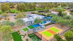 An aerial view of a residential property with a swimming pool, tennis court, and a golf course. - Scottsdale Retreat Pool Pickleball Spa (Scottsdale)