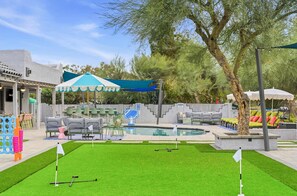 A pool area with artificial turf, a basketball hoop, and outdoor seating. - Scottsdale Retreat Pool Pickleball Spa (Scottsdale)