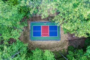 An aerial view of a tennis court surrounded by dense green foliage. - Blue Ridge Treehouse Escape Views Hot Tub (Blue Ridge)
