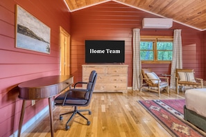 A room with a wooden ceiling, a television on a dresser, a desk with a chair, a bed, and a window with curtains. - Blue Ridge Treehouse Escape Views Hot Tub (Blue Ridge)