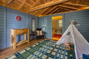 A room with a wooden ceiling, a dartboard, a mirror, a chair, a table, a rug, and a teepee. - Blue Ridge Treehouse Escape Views Hot Tub (Blue Ridge)