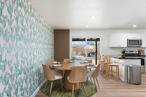 A modern kitchen with white cabinets, a microwave, and a stainless steel range hood. - Sleeps 16 Heated Pool Arcade Backyard Resort (Mesa)