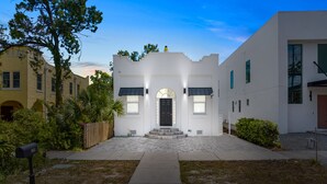 A modern two-story house with a white facade, a black front door, and a small porch. - Pineapple Paradise 1 13 min to Beach Fire Pit (Sarasota)