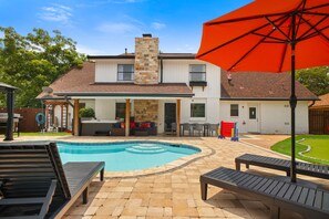 Un jardin avec une piscine, du mobilier d’extérieur et un espace patio.