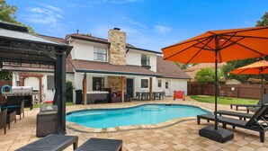 A backyard with a swimming pool, outdoor furniture, and a barbecue area. - Pool Games Pickleball Putt Putt Fun (San Antonio)